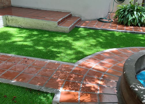 Jardín residencial con césped sintético instalado por Pasto Sintético Aldrete