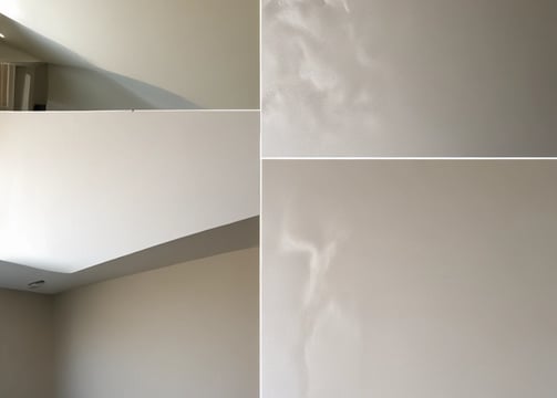 A variety of painting and decorative items are arranged on a wooden surface. There are paint samples, a paintbrush with white paint, a white paint can, wooden beads on a string, and a decorative golden container with a floral design. The background includes a paint swatch in dark green and light yellow colors.