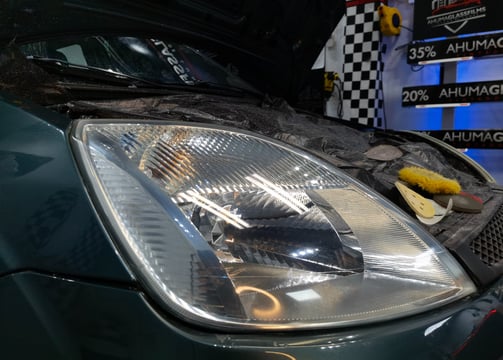 a car with a hood on it and a car in the background