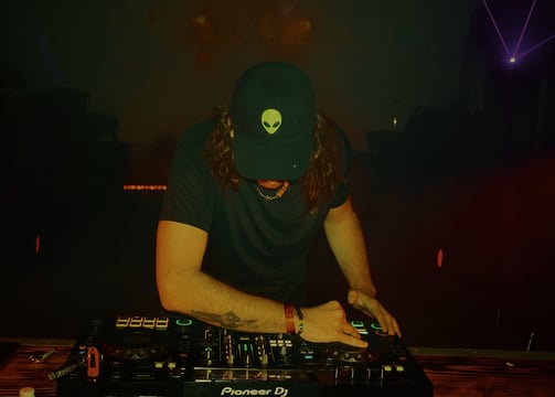a man in a hat and a hat on a dj booth