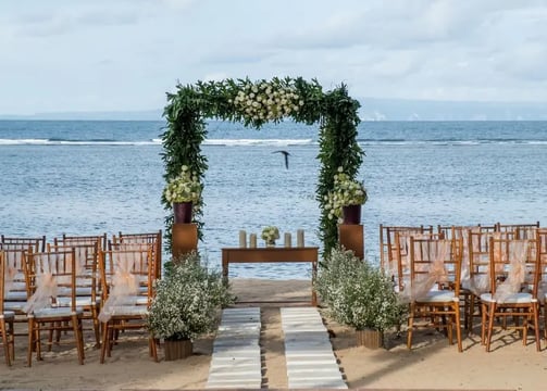 Beach wedding decoration with green drapes and tropical flowers by Pune wedding planning experts