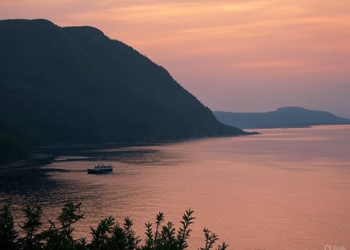 Une scène hivernale enneigée de La Gaspésie, Québec, représentant un petit village avec des maisons 