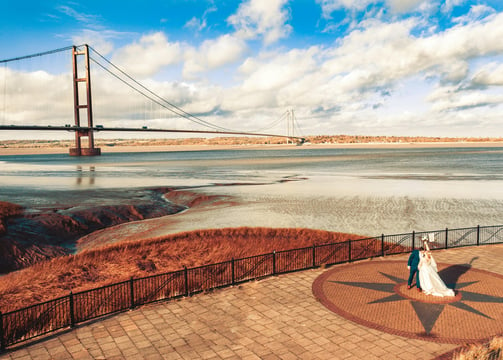 a bride and groom standing on a brick walkway