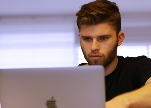 Male student is studying for the Digital SAT on his laptop