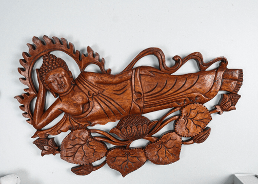 a wooden carving of a Buddha in a wooden carving of a sleeping Buddha