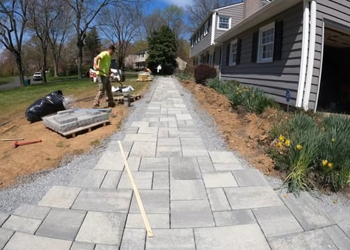 a paver project with grey paver stones being organized for a home walkway