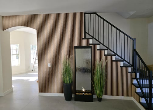 Light acoustic wood wall along staircase, enhancing sound absorption and adding a modern, natural ae