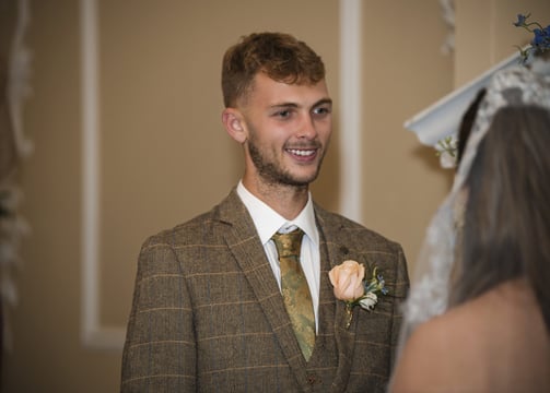 Grooms first look, smiling warmly during a wedding ceremony, wearing a checkered suit