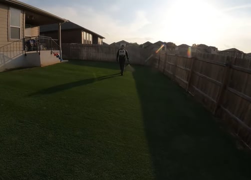 A person using a spray to keep grass free of pest
