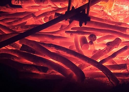 a fire pit with a fire in the background