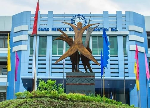 a statue of a woman holding a child in front of a building