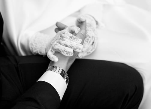 a man in a suit and tie tie holding a woman's hand