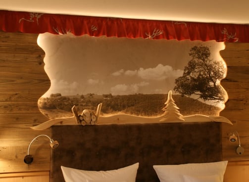 hinterleuchtetes Betthaupt mit Wandtapete in einem Gästezimmer