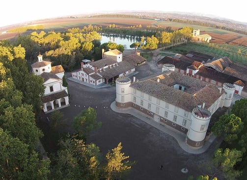 a large building with a lot of trees and a river