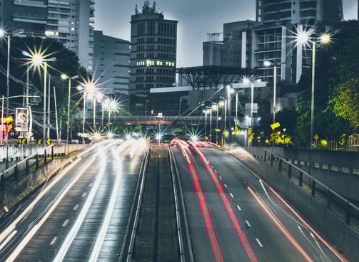 a city street scene with a train on the tracks