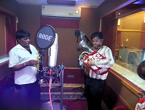 The Manohar Brass Band in a professional music recording studio, capturing their latest melodies.