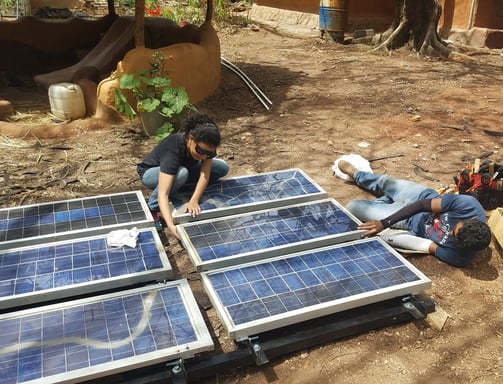 Locals assembling a solar PV rack, to be used to power a submersible DC water pump