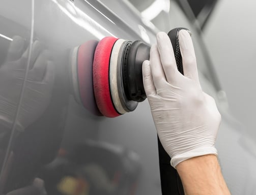 a person wearing gloves and gloves while polishing a car