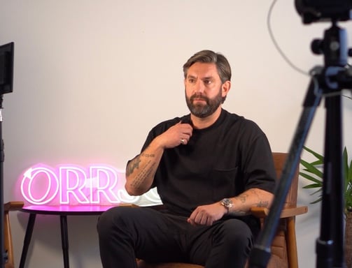 a man sitting in a chair with a camera and a camera