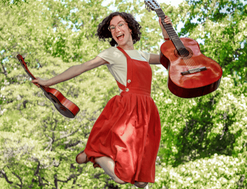 Musicienne sautant dans les air avec ukulele et guitare / a woman in red dress jumping in the air