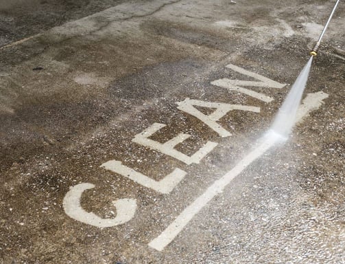Clean written on to a concrete walk way by a pressure washing services pressure washing worker