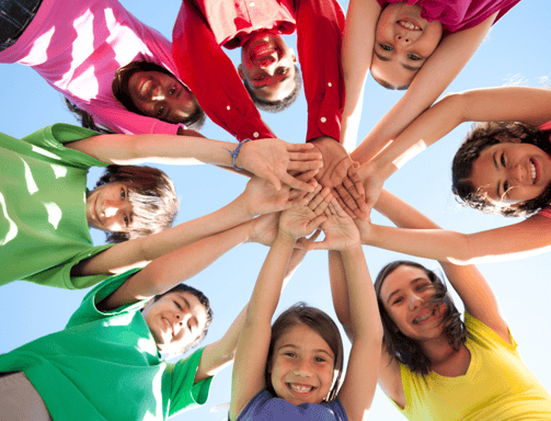 a group of people standing in a circle with their hands together