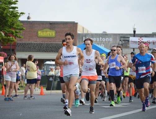A photo of runners sprinting away from the starting line of the Athens Alabama Chick Fil A 10K start