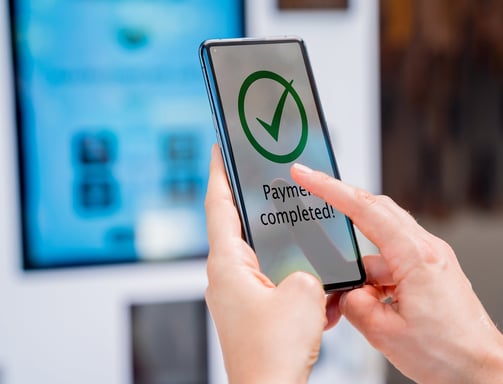 a person holding a phone that says payment completed