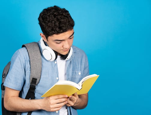 a man in a blue shirt and headphones is reading a book