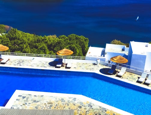 a pool with umbrellas and umbrellas on a sunny day