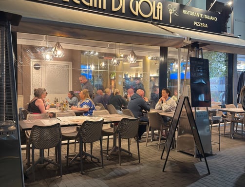 a restaurant with people sitting at tables outside