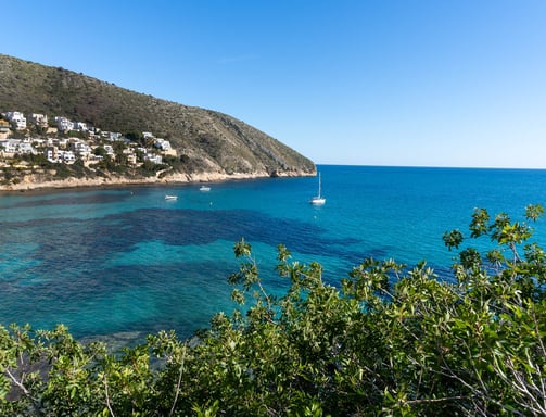 a boat in the water near a hill
