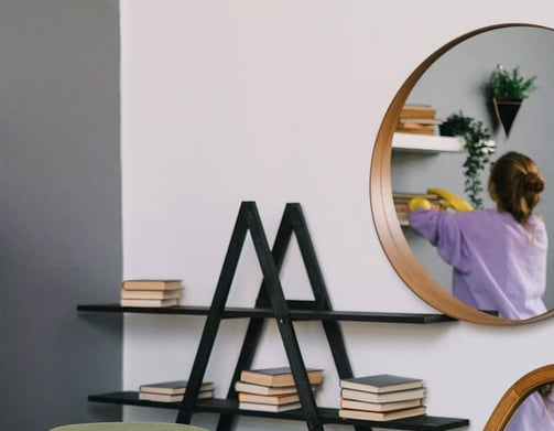 Dusting shelves during housekeeping service