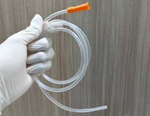 someone wearing gloves and holding a feeding tube