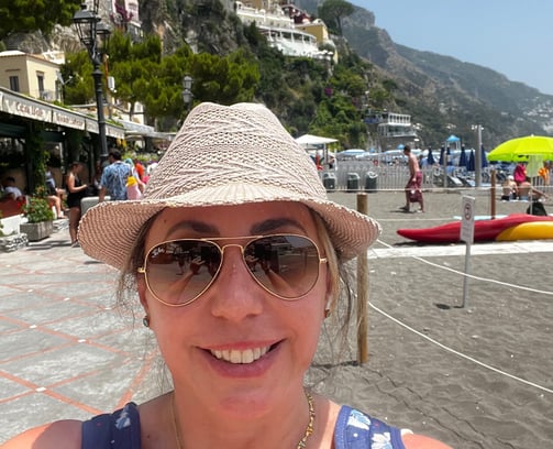 mulher com óculos de sol e chapéu em praia