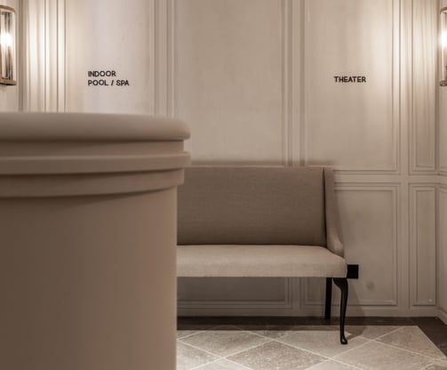 Hallway at Villa La Gratitud, featuring soft lighting, and signs for the pool, spa, and theater.