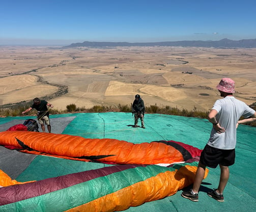 a man standing on a tarp with a paraglide