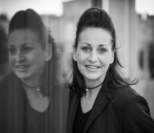 a woman in a black jacket and glasses