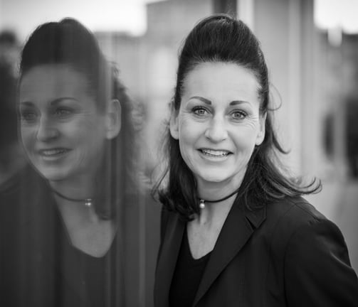 a woman in a black jacket and glasses