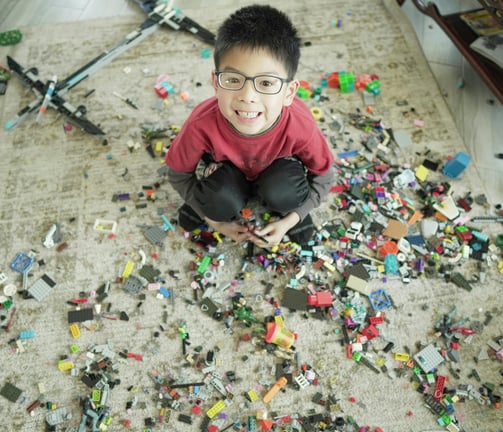https://www.pexels.com/photo/child-sitting-among-scattered-blocks-16554559/