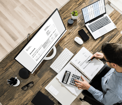 a man sitting at a desk with a calculator to do bookkeeping services and payroll