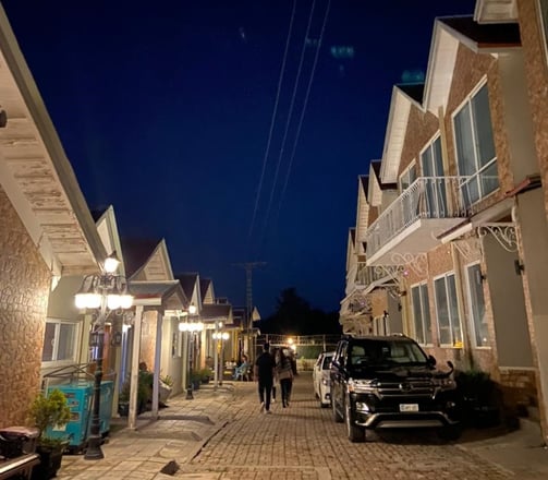 swiss cottages bhurban street scene with a car parked on the side of the road
