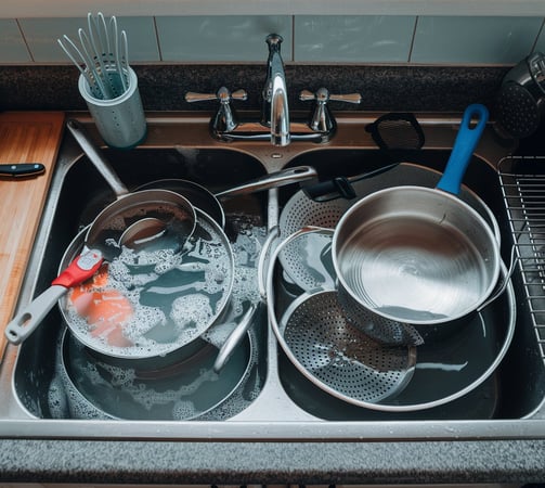 a kitchen sink with pots and pans of cooking utensils