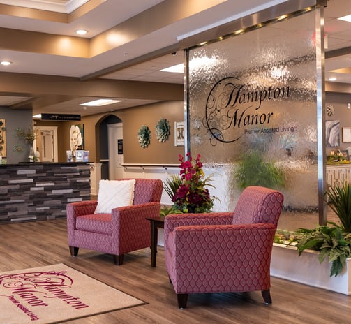 a hotel lobby area with chairs and a reception table