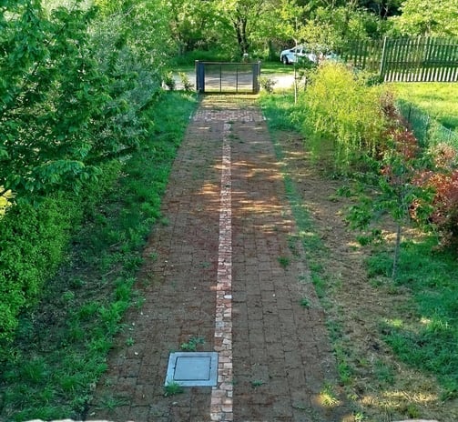 Giardino privato in vendita con vialetto pavimentato e accesso carrabile.