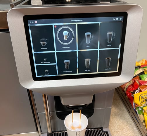 Egro touchscreen espresso machine preparing cappuccino in a self-service station