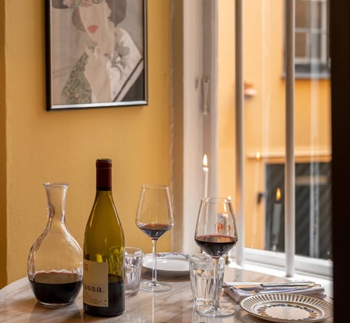 a table with wine glasses and wine bottles at Restaurant Gabrielle in Copenhagen