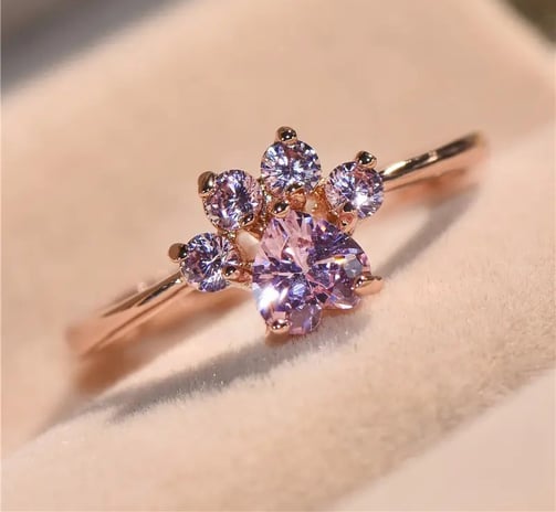 a pink ring with a pink cat themed paw ring