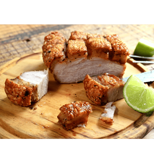 a piece of fried pork with a knife and lime wedges (chicharon)