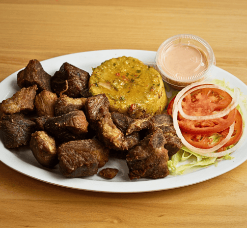 a plate of food with fried pork mofongo and vegetables carne frita con mofongo